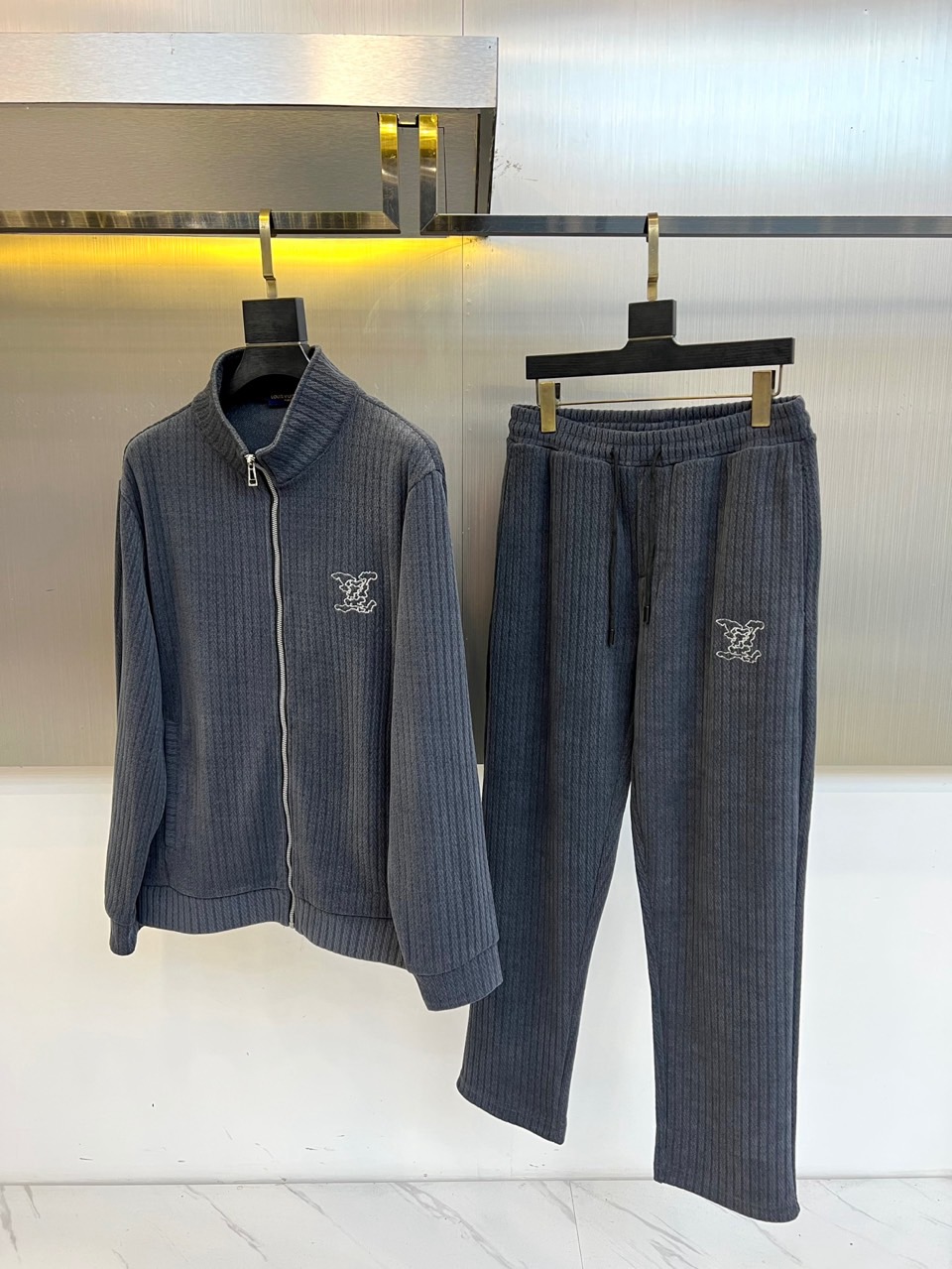 1v威登、2025秋冬新品运动套装，以深灰色竖条纹纹理面料重塑奢华运动风尚。套装包含立领拉链外套与束脚运