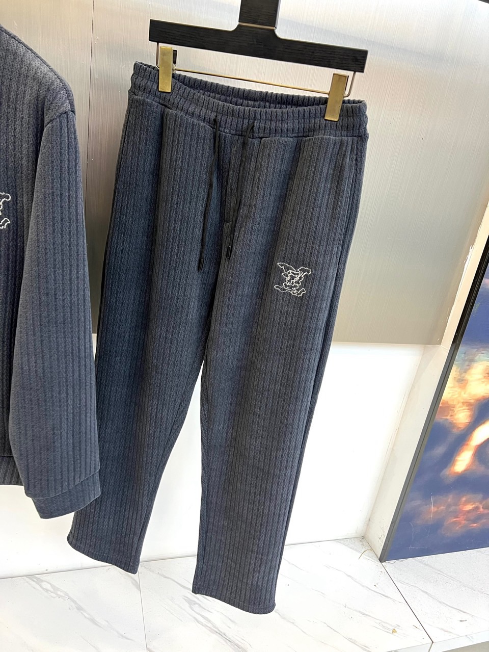 1v威登、2025秋冬新品运动套装，以深灰色竖条纹纹理面料重塑奢华运动风尚。套装包含立领拉链外套与束脚运