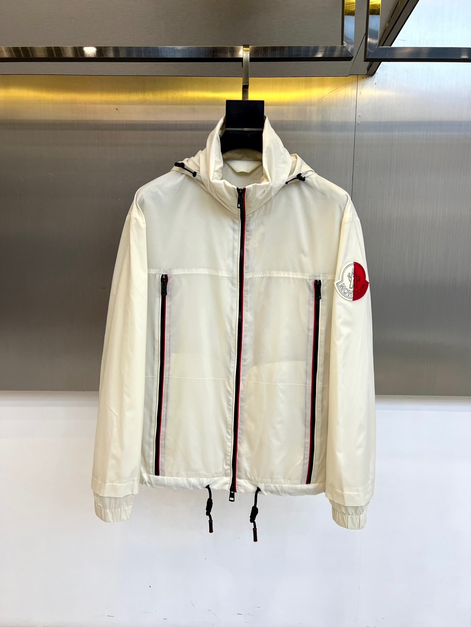 MON蒙口、2025秋冬新品连帽夹克外套，以纯净白色演绎现代都市运动美学。连帽设计搭配可调节抽绳，增强实