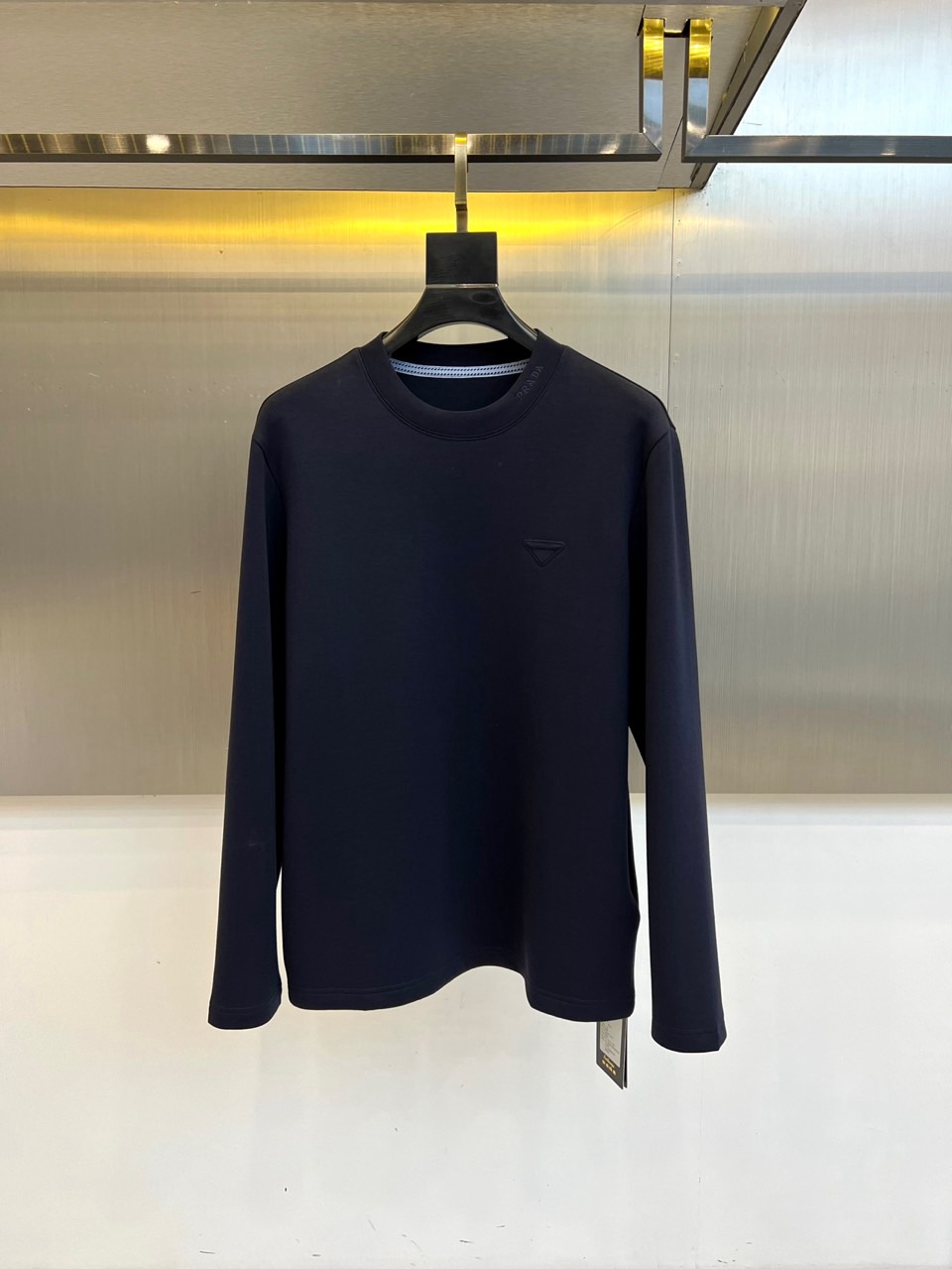 Prad普拉达、2025秋冬新品男士白色长袖T恤，以极简主义美学诠释现代奢华。本品采用320克莫代尔空气