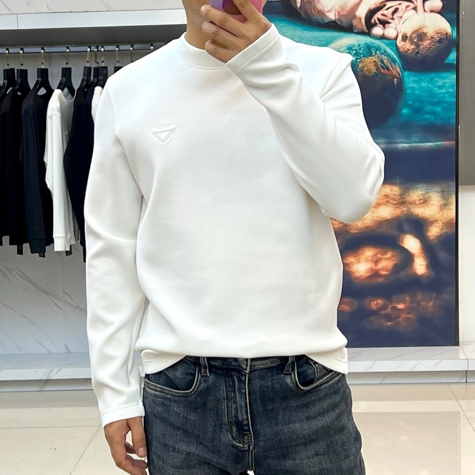 Prad普拉达、2025秋冬新品男士白色长袖T恤，以极简主义美学诠释现代奢华。本品采用320克莫代尔空气