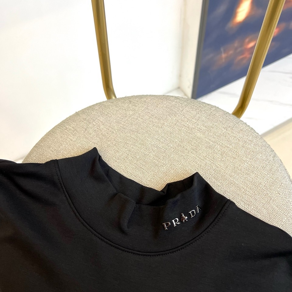Prad普拉、2025秋冬新品 极简高领长袖羊毛🐑T恤打底衫。这款高领上衣采用立体剪裁设计，简约圆领搭配