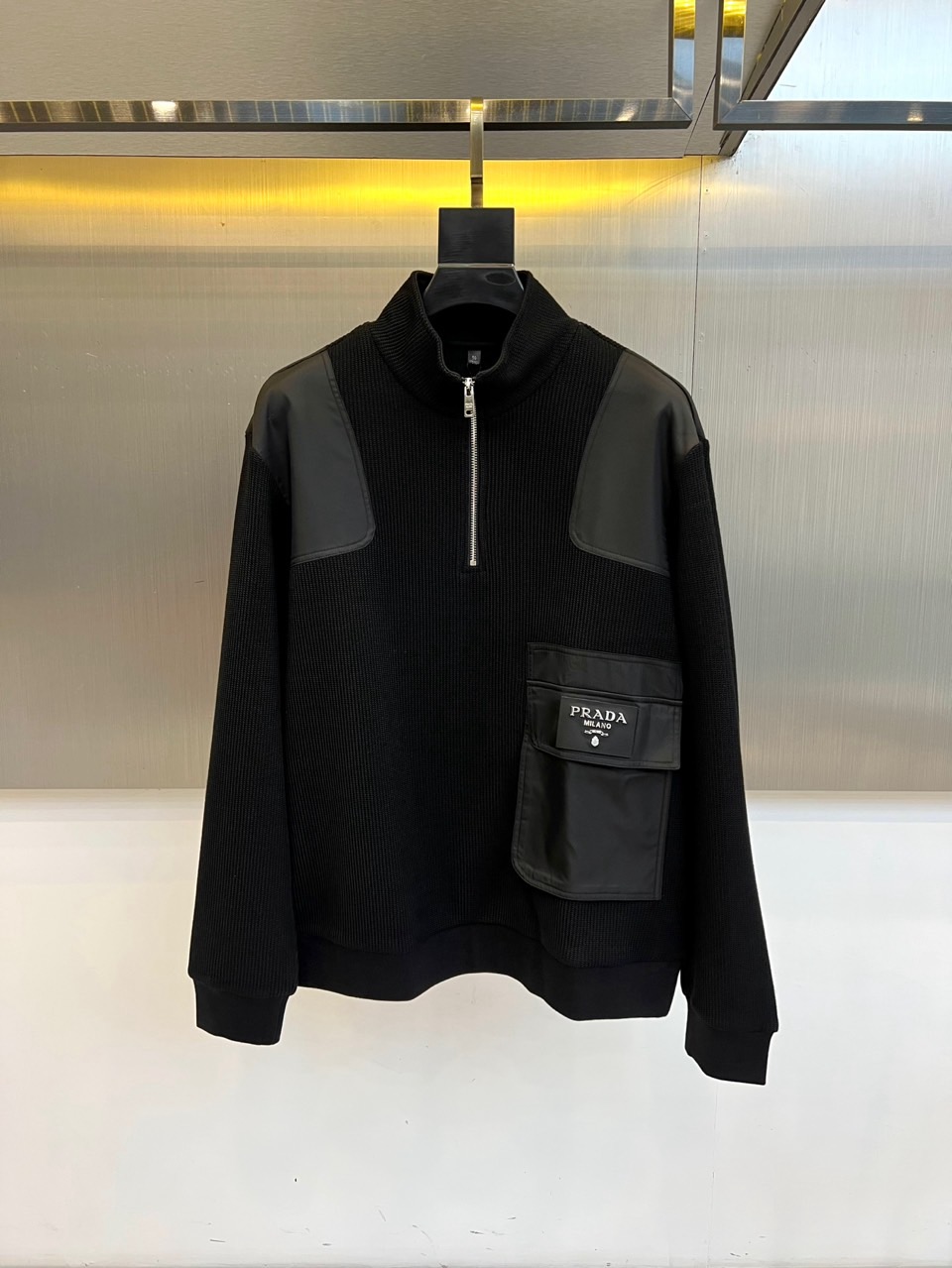 Prad普拉、2025秋冬新品 男士PRADA立领针织卫衣，这款黑色卫衣采用立领半拉链设计，肩部创新运用