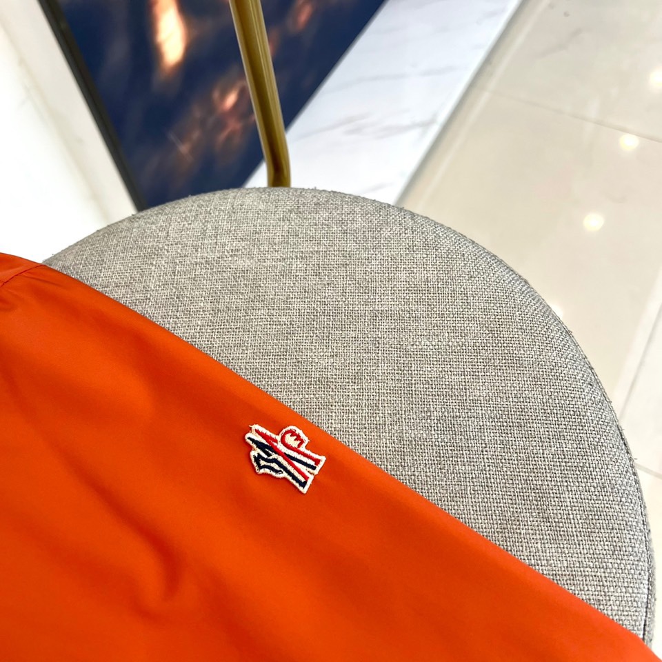 Mon蒙口、2025秋冬新品蒙口防风冲锋衣夹克，以醒目的橙红色调诠释户外机能美学。采用连帽设计搭配全拉链