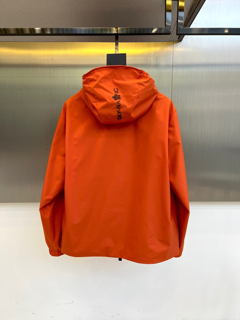 Mon蒙口、2025秋冬新品蒙口防风冲锋衣夹克，以醒目的橙红色调诠释户外机能美学。采用连帽设计搭配全拉链