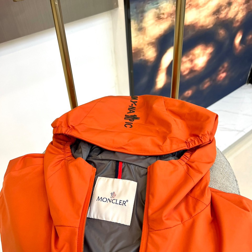 Mon蒙口、2025秋冬新品蒙口防风冲锋衣夹克，以醒目的橙红色调诠释户外机能美学。采用连帽设计搭配全拉链