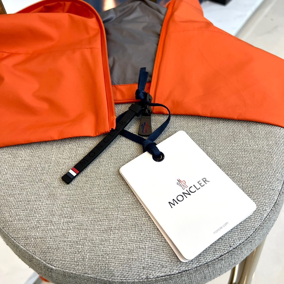 Mon蒙口、2025秋冬新品蒙口防风冲锋衣夹克，以醒目的橙红色调诠释户外机能美学。采用连帽设计搭配全拉链