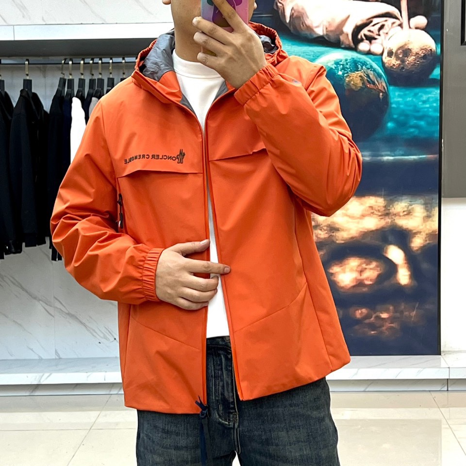 Mon蒙口、2025秋冬新品蒙口防风冲锋衣夹克，以醒目的橙红色调诠释户外机能美学。采用连帽设计搭配全拉链