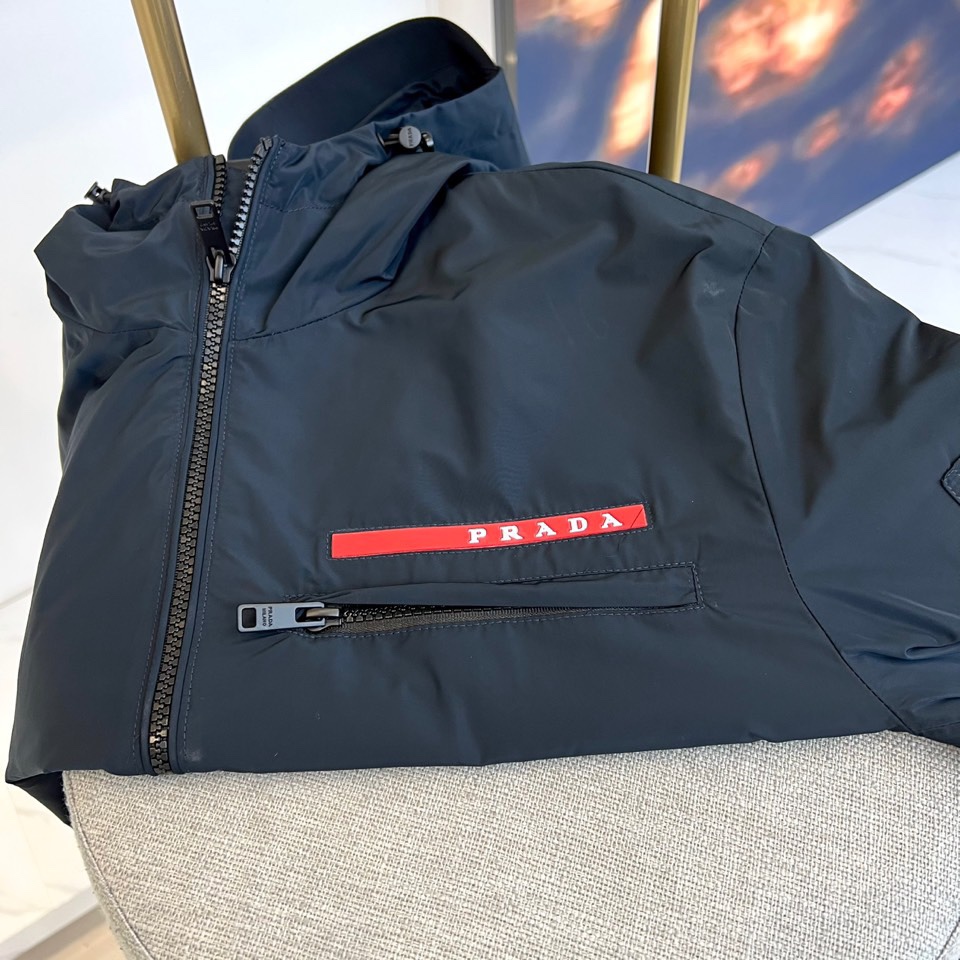 Prad普拉、2025s早春最新发售红标夹克外套，衣身选用工业感十足的Re-Nylon再生尼龙打造，衣身