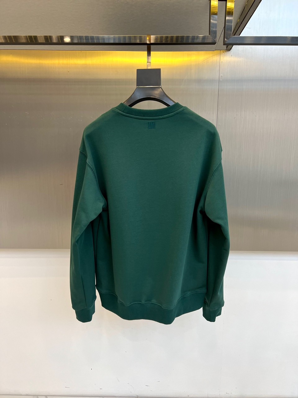 AMI 2025秋冬新品圆领卫衣，以纯净简约的白色为基调，打造秋冬清爽时尚感。胸前点缀品牌标志性红色爱心