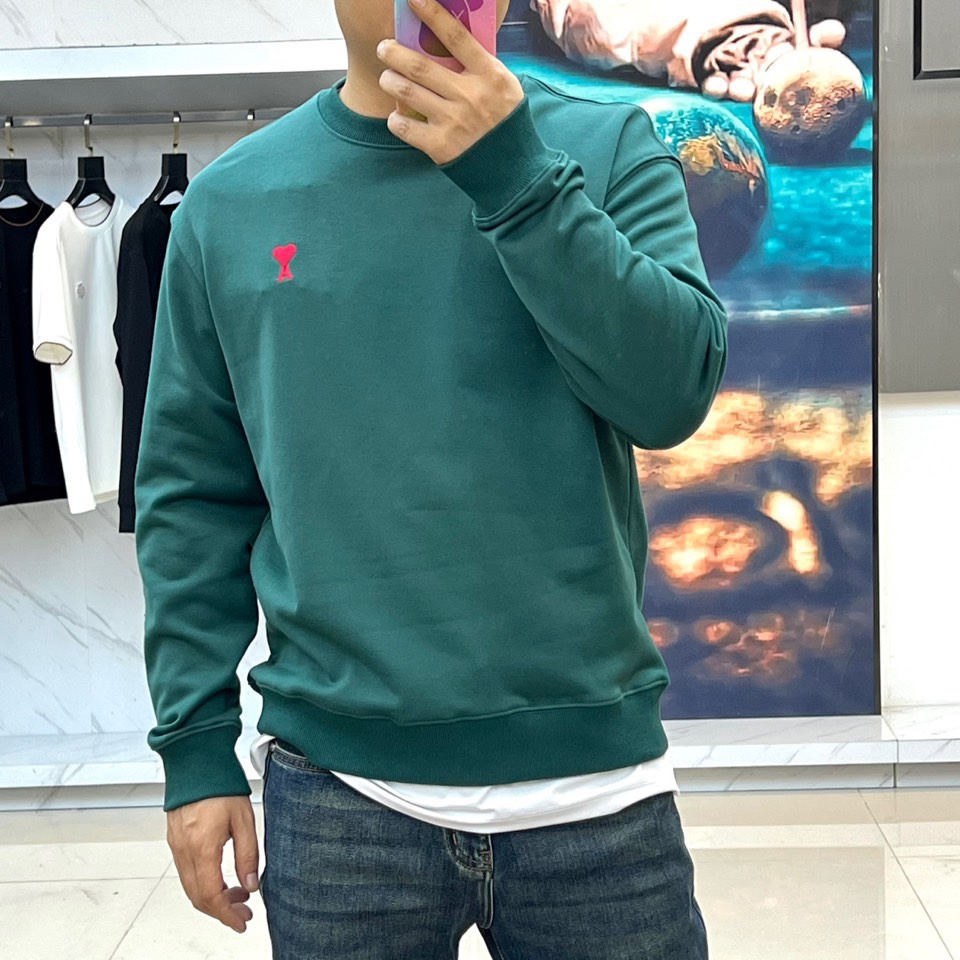 AMI 2025秋冬新品圆领卫衣，以纯净简约的白色为基调，打造秋冬清爽时尚感。胸前点缀品牌标志性红色爱心