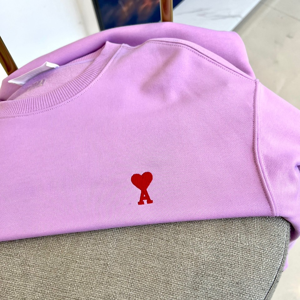 AMI 2025秋冬新品圆领卫衣，以纯净简约的白色为基调，打造秋冬清爽时尚感。胸前点缀品牌标志性红色爱心