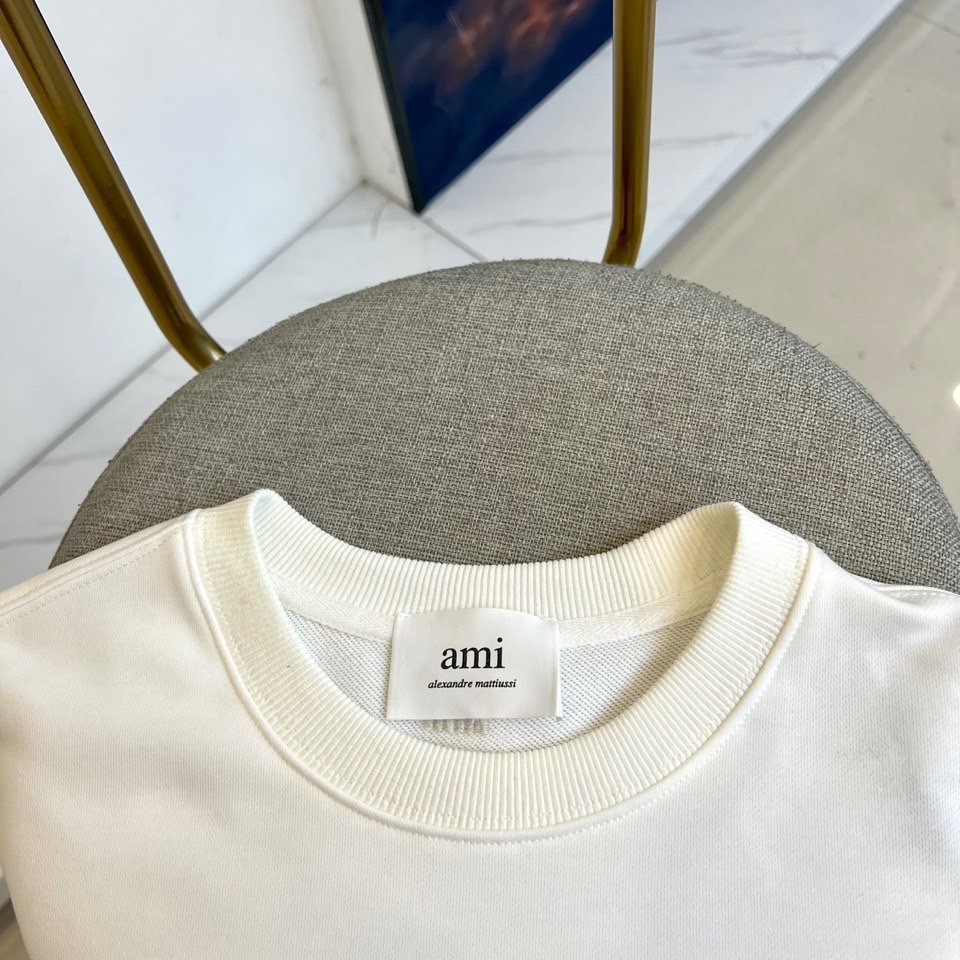 AMI 2025秋冬新品圆领卫衣，以纯净简约的白色为基调，打造秋冬清爽时尚感。胸前点缀品牌标志性红色爱心