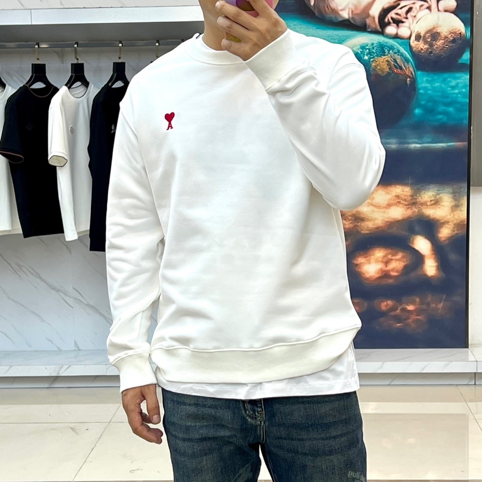 AMI 2025秋冬新品圆领卫衣，以纯净简约的白色为基调，打造秋冬清爽时尚感。胸前点缀品牌标志性红色爱心