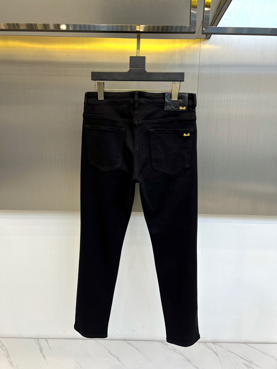 Fend芬迪、2025秋冬新品黑色牛仔裤，以极致纯黑诠释当代暗黑美学。后腰处装饰品牌标志性深色皮革标签，