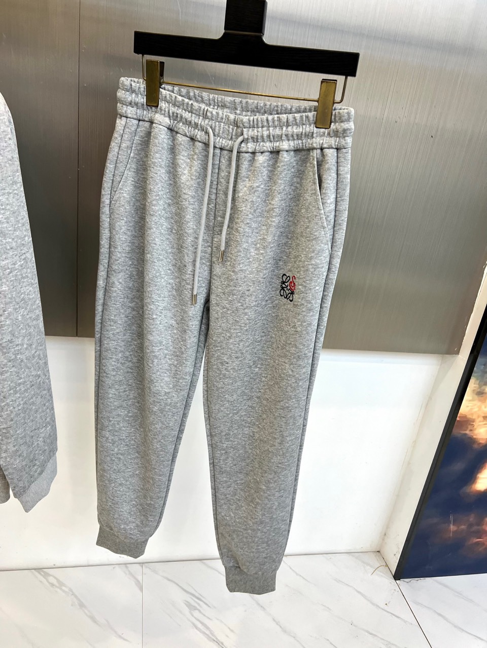 LOEWE罗意威、2025秋冬新品灰色运动套装，以简约高级的灰调演绎现代休闲美学。套装包含连帽拉链卫衣与