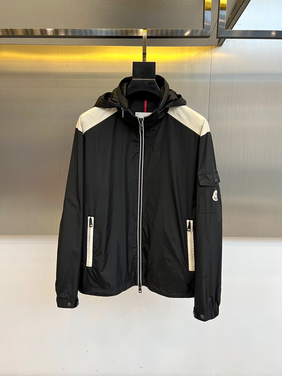 NO:545615,MON cover and autumn and winter new hooded jackets interpret modern urban aesthetics with classic black and white contrasting design. The shoulder innovatively adopts white splicing design, forming a sharp visual contrast with the black body, breaking the monotony. The hooded design is matched with smooth zipper opening and closing, and practical zipper pockets on the chest and both sides are equipped with cleverly blending functionality and fashion sense. The left sleeve is embellished with the iconic brand logo to highlight the luxury genes. It is made of high-performance technology fabrics, combining excellent protective performance and support.  The texture is included. Its style is perfectly balanced with sports and leisure and high-end fashion, neat tailoring ensures freedom of movement, and the black and white color matching is classic and versatile. It can not only match casual pants to create a daily street look, but also meet the needs of light outdoor activities. This jacket has the iconic contrasting color design and practical details, and has become a must-have item that has both recognition and practical wear in autumn and winter. Size 1-5 (model 173, 143 catties upper body 2 sizes), Moncler, jackets  & coats,hats,alexander wang19860909MON蒙口、秋冬新品连帽夹克,以经典黑白撞色设计演绎现代都市美学.肩部创新采用白色拼接设计,与黑色主体形成鲜明视觉对比,打破单调感.连帽设计搭配顺滑拉链开合,胸前与两侧均配备实用拉链口袋,巧妙融合功能性与时尚感.左袖点缀标志性品牌徽标,彰显奢华基因.选用高性能科技面料打造,兼具出色防护性能与挺括质感.其风格完美平衡运动休闲与高端时尚,利落剪裁确保活动自由度,黑白配色经典百搭.既能搭配休闲裤打造日常出街造型,亦可应对户外轻度活动需求.这件夹克以标志性撞色设计与实用细节,成为秋冬季节兼具辨识度与实穿性的必备单品.1-5码（模特173,143斤上身2码）,,Moncler,jackets & coats,hats,alexander wang,Men's clothing