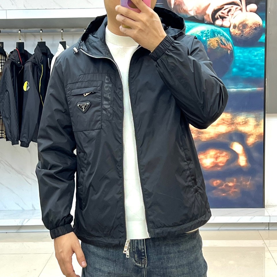 Prad普拉、2025秋冬新品黑色连帽夹克外套，以极简设计诠释现代都市美学。采用品牌标志性的高科技尼龙面