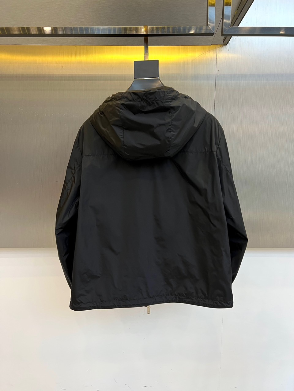 Prad普拉、2025秋冬新品黑色连帽夹克外套，以极简设计诠释现代都市美学。采用品牌标志性的高科技尼龙面