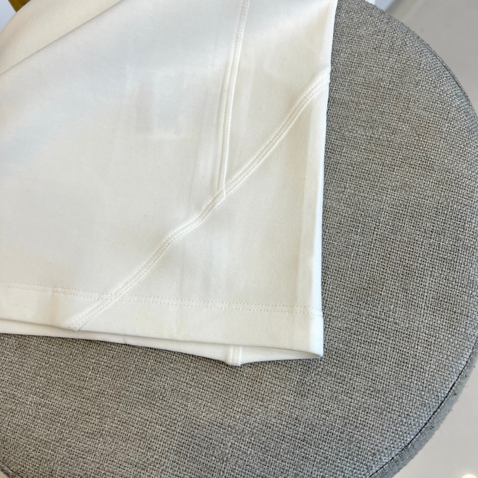 Prad普拉、2025秋冬新品P家简约长袖上衣这款白色长袖上衣采用经典圆领设计与立体剪裁，左胸处装饰品牌