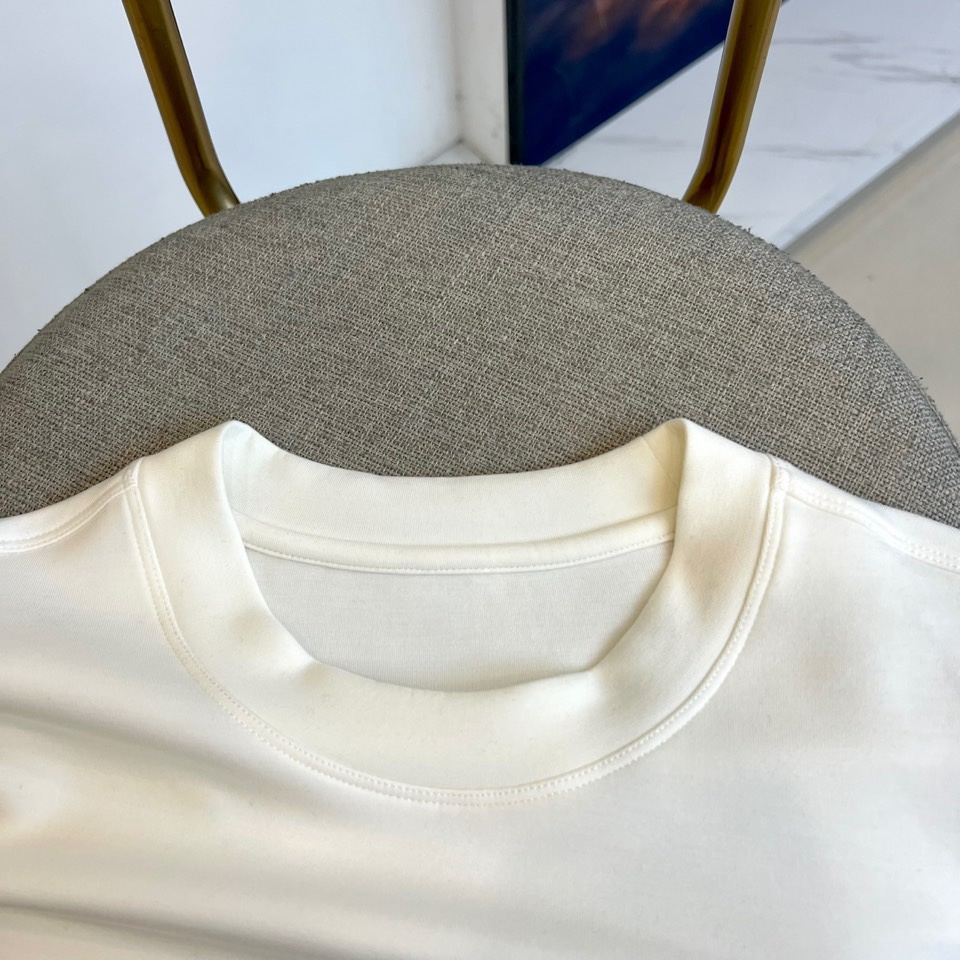 Prad普拉、2025秋冬新品P家简约长袖上衣这款白色长袖上衣采用经典圆领设计与立体剪裁，左胸处装饰品牌