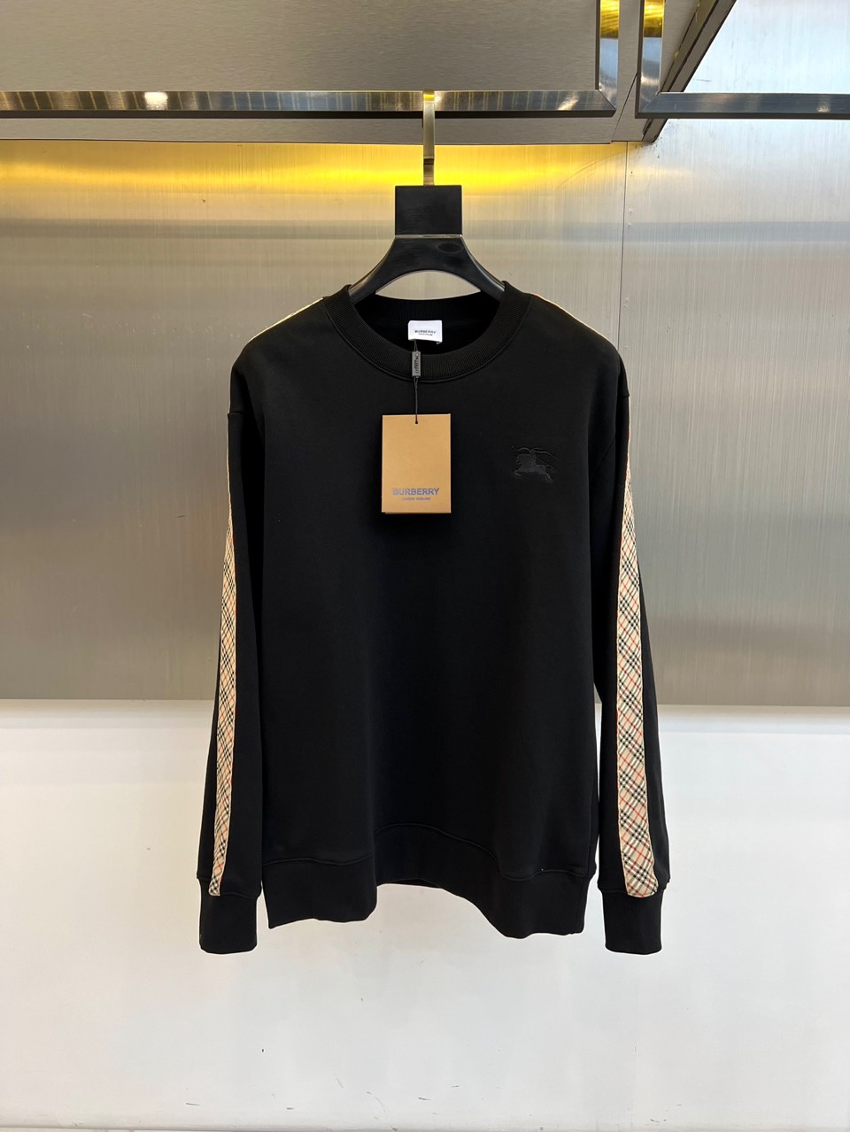 NO:564096,Burberry's new round-neck sweatshirt for autumn and winter is made of pure white cotton fabric to create a simple and elegant daily item. The left chest is decorated with the brand's classic pony logo embroidery, using delicate stitching to highlight the low-key and luxurious brand genes. The sleeves are cleverly integrated into Burberry's signature plaid splicing design, injecting a retro British atmosphere into the solid color base. The loose yet elegant tailoring takes into account comfort and sophistication, and the cuffs and hem are ribbed to enhance the three-dimensionality of the overall silhouette.   This sweatshirt perfectly combines classic aesthetics and modern casual style. It can be paired with jeans for a light urban retro look, or layered with coats and skirts to create a layered look. From daily outings to casual social occasions, one piece can easily handle a variety of scenes, interpreting the leisurely British luxury attitude. S-XL (model 173,143 pounds, upper body size M),, burberry, burberry, hoodie, sweatshirts, skirts, jeans, alexander wang19860909Bur巴宝莉、秋冬新品圆领卫衣,以纯净白色棉质面料打造简约优雅的日常单品.左胸处饰有品牌经典小马标刺绣,以细腻针脚凸显低调奢华的品牌基因.双袖巧妙融入巴宝莉标志性格纹拼接设计,为纯色基底注入复古英伦气息.宽松而不失利落的剪裁兼顾舒适性与精致感,袖口与下摆采用罗纹收束设计,提升整体轮廓的立体度. 这款卫衣完美融合经典美学与现代休闲风格,既可搭配牛仔裤演绎都市轻复古,也能与大衣、半裙叠穿营造层次感造型.从日常出街到休闲社交场合,一件轻松驾驭多种场景,诠释从容不迫的英式奢华态度.S-XL（模特173,143斤上身M码）,,burberry,burberry,hoodie,sweatshirts,skirts,jeans,alexander wang,Men's clothing