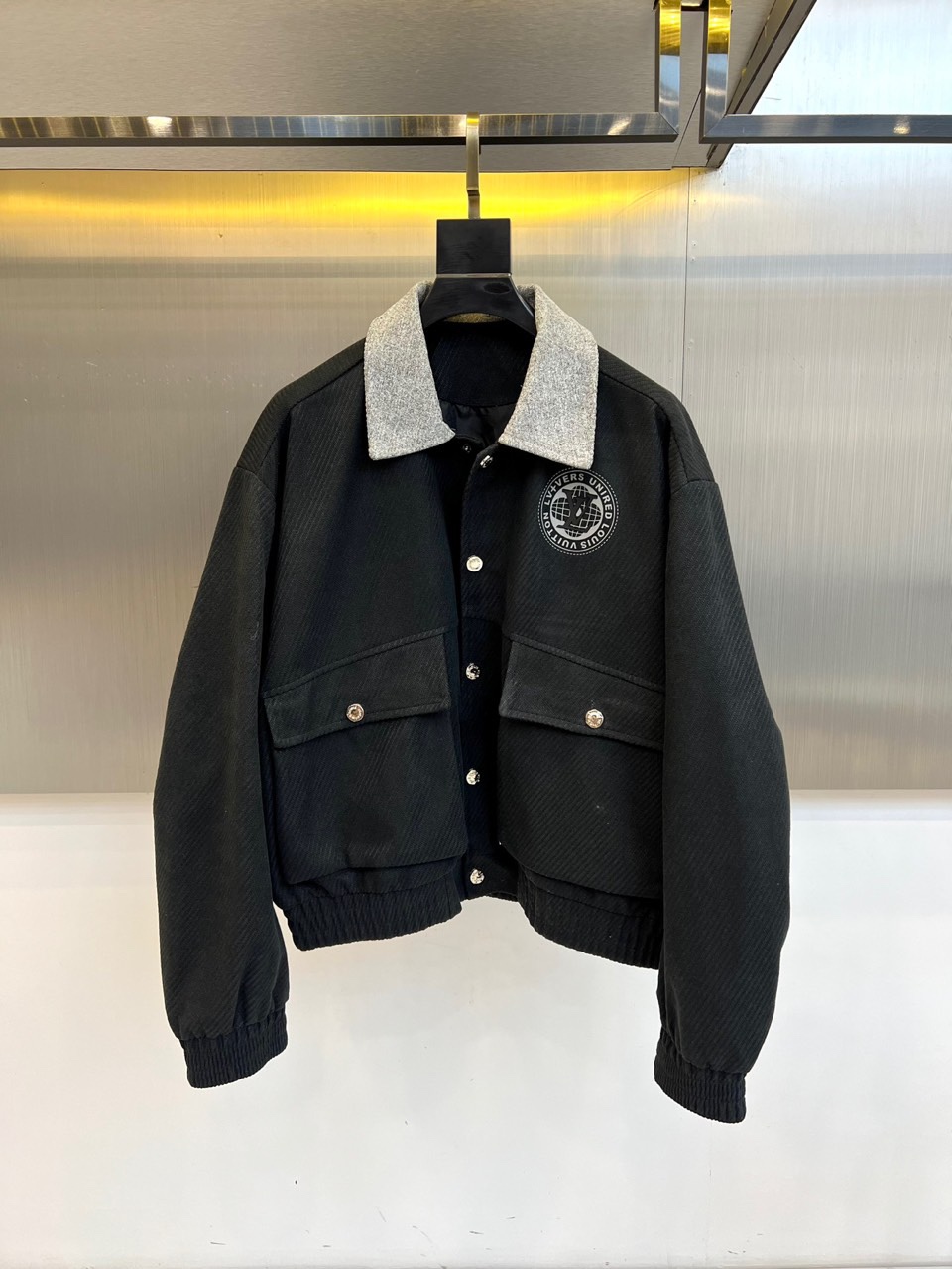 NO:564090,1v Vuitton's new autumn and winter men's jackets redefine autumn and winter outerwear with the brand's iconic travel aesthetics and modern urban style. This product adopts a contrasting design between a light gray body and a dark brown collar. The stand-up collar shape is matched with smooth zipper opening and closing, and the lines are simple and neat. The classic LV round badge is decorated on the chest, low-key highlighting the brand identity; symmetrical large pockets on both sides are decorated with metal snaps, taking into account practical functions and exquisite details. The hem and cuffs are designed with knitted cuffs to enhance warmth and improve warmth.  It adds a retro casual feel. The tailoring is slim and smooth, ensuring comfort and a straight silhouette. The light gray tone presents a high-end texture and can be paired with casual pants to create an urban fashion style. It can also collide with formal pants to create a new business casual style. Louis Vuitton uses exquisite craftsmanship and innovative design to sublimate this jacket into a must-have item that combines luxury and practicality, perfectly meeting the dressing needs of men in various occasions in autumn and winter. 48-56 (model 173, 143 pounds, upper body size 50),, louis   vuitton,louis vuitton,jackets & coats,jackets & coats,alexander wang198609091v威登、秋冬新品男士夹克外套,以品牌标志性的旅行美学与现代都市风格重新定义秋冬外套.本品采用浅灰色主体与深棕色衣领的对比设计,立领造型搭配顺滑拉链开合,线条简洁利落.胸前饰有经典LV圆形徽章,低调彰显品牌身份；两侧对称大口袋配以金属按扣装饰,兼顾实用功能与精致细节.下摆及袖口采用针织收口设计,增强保暖性并增添复古休闲感.剪裁修身流畅,确保穿着舒适与挺拔轮廓.浅灰色调呈现高级质感,可搭配休闲裤打造都市时尚风格,亦能与正装裤碰撞出商务休闲新风尚.路易威登以精湛工艺与创新设计,将这款夹克升华为兼具奢华与实用性的必备单品,完美满足秋冬男士多样场合的着装需求.48-56（模特173,143斤上身50码）,,louis vuitton,louis vuitton,jackets & coats,jackets & coats,alexander wang,Men's clothing