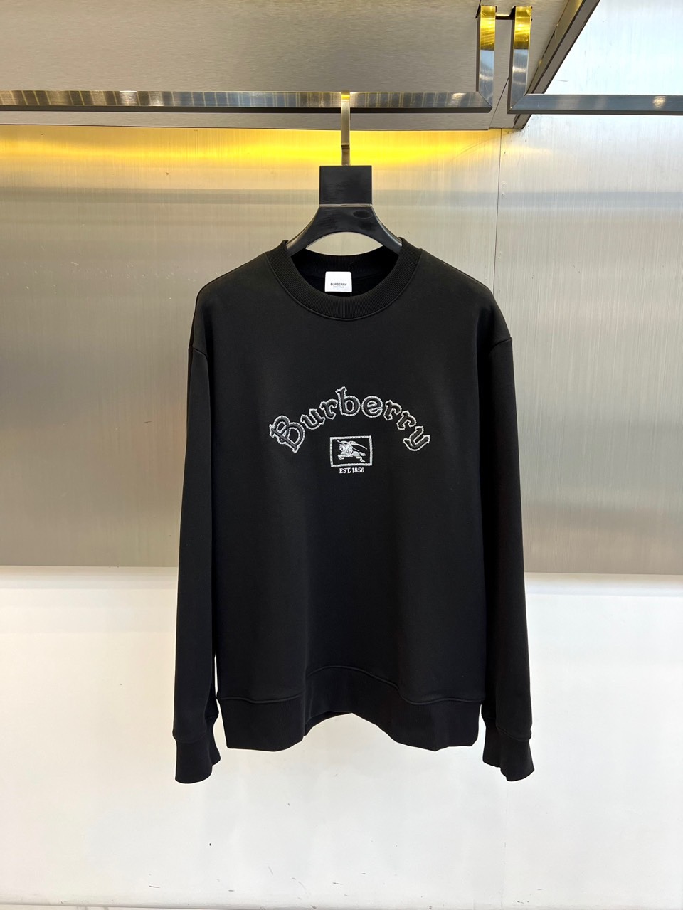 NO:564078,Burberry's new round-neck sweatshirt for autumn and winter adopts a classic and simple round-neck design and is made of high-quality cotton fabric to create a soft and comfortable wearing experience. The chest is decorated with exquisite 'Burberry' brand embroidery words and iconic small square patterns, low-key highlighting the brand identity. The loose-fitting tailoring retains a casual and casual feel while maintaining an elegant silhouette. The cuffs and hem are designed with ribbed cuffs to ensure a crisp fit.   The overall style perfectly combines British classics and modern leisure, and the pure white tone shows a simple and high-end sense. It can be paired with jeans to create a daily urban look, or layered with a coat or skirt to present a sophisticated sense of layering. A must-have item for autumn and winter that has both brand recognition and practicality, interpreting a timeless and elegant fashion attitude. S-XL (model 173,143 pounds, upper body size M),, burberry, burberry, hoodie, sweatshirts, skirts, jeans, alexander wang19860909Bur巴宝莉、秋冬新品圆领卫衣,采用经典简约的圆领设计,以高品质棉质面料打造柔软舒适的穿着体验.胸前饰有精致的'Burberry'品牌刺绣字样及标志性小方块图案,低调彰显品牌身份.宽松合身的剪裁既保留休闲随性感,又保持优雅轮廓.袖口与下摆采用罗纹收口设计,确保版型挺括. 整体风格完美融合英伦经典与现代休闲,纯净白色调展现简约高级感.既可搭配牛仔裤打造日常都市造型,也能与大衣或半裙叠穿呈现精致层次感.一件兼具品牌辨识度与实用性的秋冬必备单品,诠释永恒优雅的时尚态度.S-XL（模特173,143斤上身M码）,,burberry,burberry,hoodie,sweatshirts,skirts,jeans,alexander wang,Men's clothing