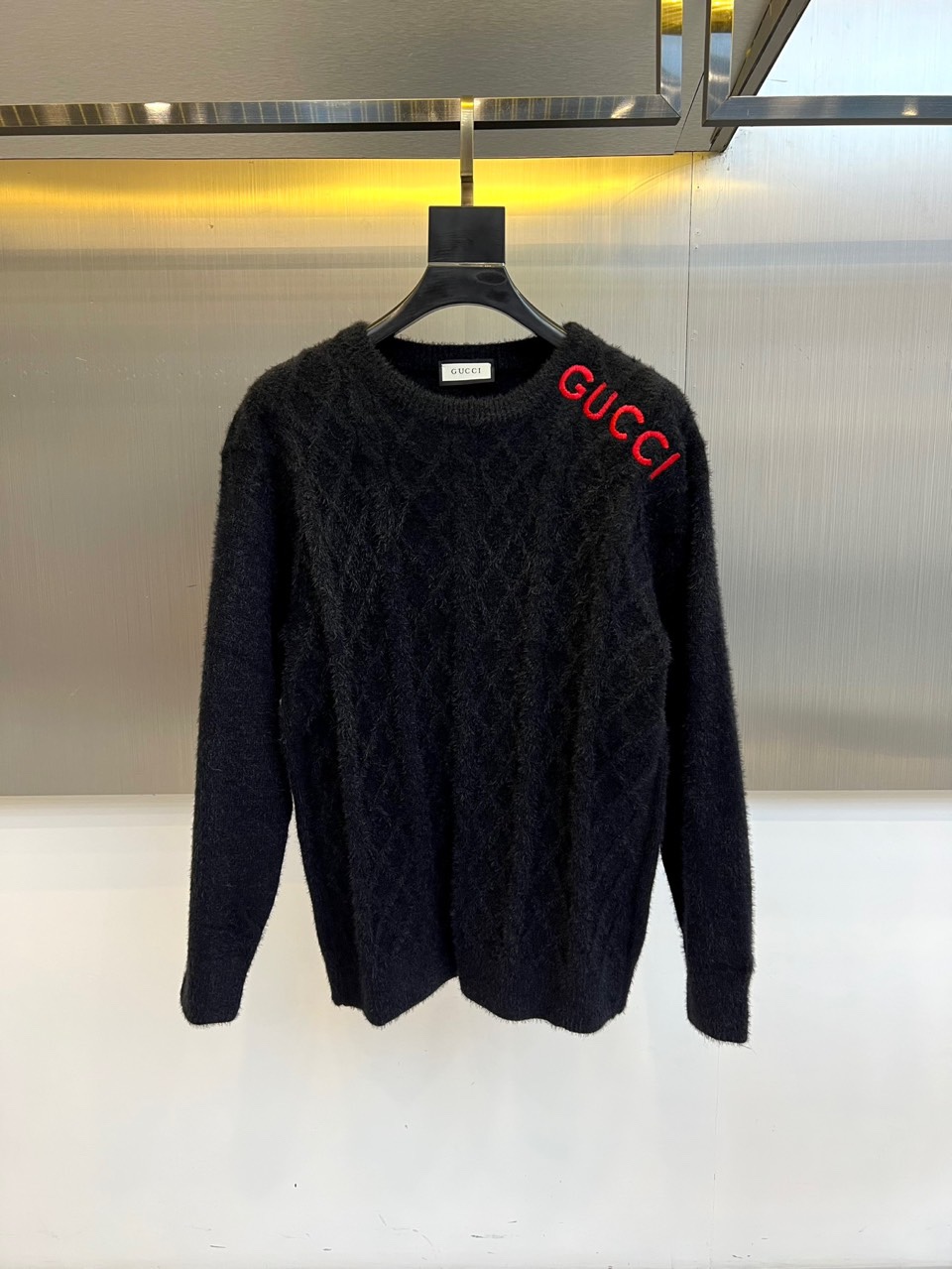 NO:564109,Gucci, new autumn and winter products   GUCCI logo embroidered sweater. This white sweater has a classic round neck design. The body is decorated with a delicate diamond weave texture. The left shoulder is embellished with eye-catching red GUCCI brand logo embroidery, which contrasts sharply with the pure white base. The cotton fabric brings a soft and skin-friendly wearing experience, and the ribbed cuffs and hem ensure a crisp fit. The red embroidered logo continues the brand's classic genes, and the white main tone highlights simplicity and high-end.  A sense of class. It can be worn alone to show a casual fashion style, or can be used as an inner layer to create a layered look. It is suitable for daily outings, gatherings with friends and other diverse scenes. Through the combination of iconic elements and comfortable fabrics, it interprets GUCCI's aesthetic concept of integrating Italian luxury with daily wearability. 48-56 (model is 173, 143 pounds, upper body size 50),, gucci, gucci, alexander  wang19860909Gucc古驰、秋冬新品 GUCCI标志刺绣针织衫,这款白色针织衫采用经典圆领设计,衣身饰有精致的菱形编织纹理,左肩处点缀醒目的红色GUCCI品牌标识刺绣,与纯净白色基底形成鲜明对比.棉质面料带来柔软亲肤的穿着体验,罗纹袖口与下摆确保版型挺括.红色刺绣标识延续品牌经典基因,白色主调彰显简约高级感.既可单穿展现休闲时尚风格,也可作为内搭打造层次造型.适合日常出街、朋友聚会等多元场景,通过标志性元素与舒适面料的结合,诠释GUCCI将意式奢华与日常实穿性相融合的美学理念.48-56（模特173,143斤上身50码）,,gucci,gucci,alexander wang,Men's clothing