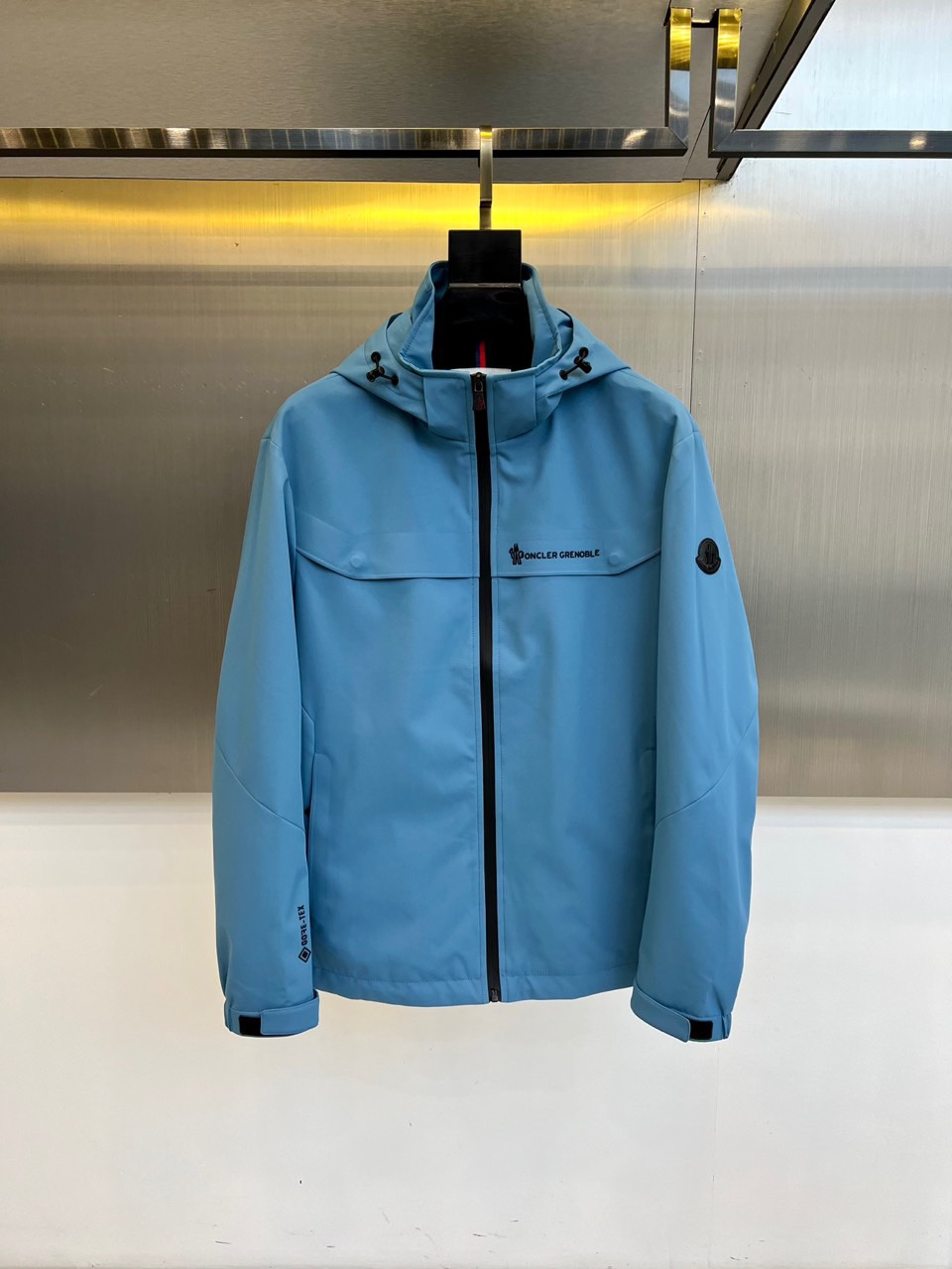 NO:601524,Mon, 2025 autumn and winter new product MONCLER GRENOBLE technology mountaineering jacket, this light blue hooded jacket is designed with professional outdoor specifications, with 'MONCLER' decorated on the chest and left arm respectively.  GRENOBLE' series logo, highlighting the genes of mountain adventure. It is equipped with GORE-TEX technical fabric, which has excellent windproof, waterproof and breathable performance, and is suitable for extreme outdoor environments. Three-dimensional tailoring is combined with an adjustable windproof hood, and a built-in drawstring system at the hem enhances sealing. Laser-cut pockets and waterproof zipper details show precision craftsmanship, and breathable zippers under the arms improve transportation.  Dynamic comfort. The light blue tone breaks through the traditional outdoor clothing color frame, which can not only cope with the challenges of high-altitude mountaineering, but also integrate into urban outdoor wearing scenes. Through the integration of professional technology and fashionable colors, it redefines new standards of high-performance luxury outdoor clothing. 48-56 (model is 173, 143 pounds, upper body size 50), Moncler, jackets  & coats,hats,alexander wang19860909Mon蒙口、2025秋冬新品 MONCLER GRENOBLE科技登山夹克,这款浅蓝色连帽夹克采用专业户外规格设计,胸前与左臂分别饰有'MONCLER GRENOBLE'系列标识,彰显高山探险基因.搭载GORE-TEX科技面料,具备卓越防风防水与透气性能,适应极端户外环境.立体剪裁配合可调节防风帽,下摆内置抽绳系统增强密封性.激光切割口袋与防水拉链细节展现精密工艺,腋下透气拉链提升运动舒适度.浅蓝色调突破传统户外服饰色彩框架,既可应对高海拔登山挑战,也能融入都市户外穿搭场景.通过专业科技与时尚色彩的融合,重新定义高性能奢华户外着装新标准.48-56（模特173,143斤上身50码）,,Moncler,jackets & coats,hats,alexander wang,Men's clothing