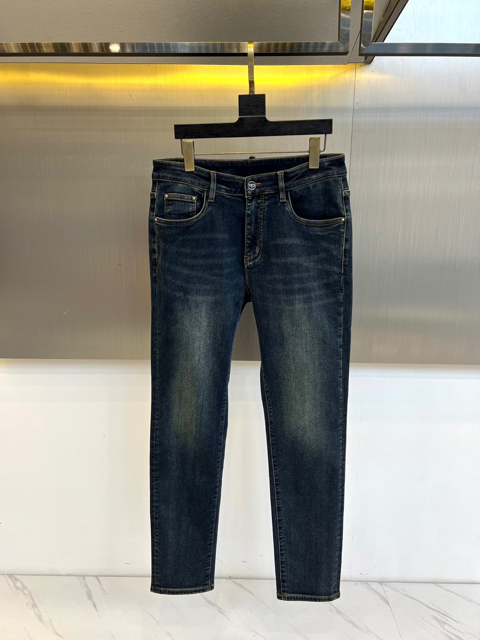 VT华伦天奴、2025秋冬新品深蓝色牛仔裤，采用高密度棉质面料打造挺括且柔软的穿着体验。后袋饰有品牌标志