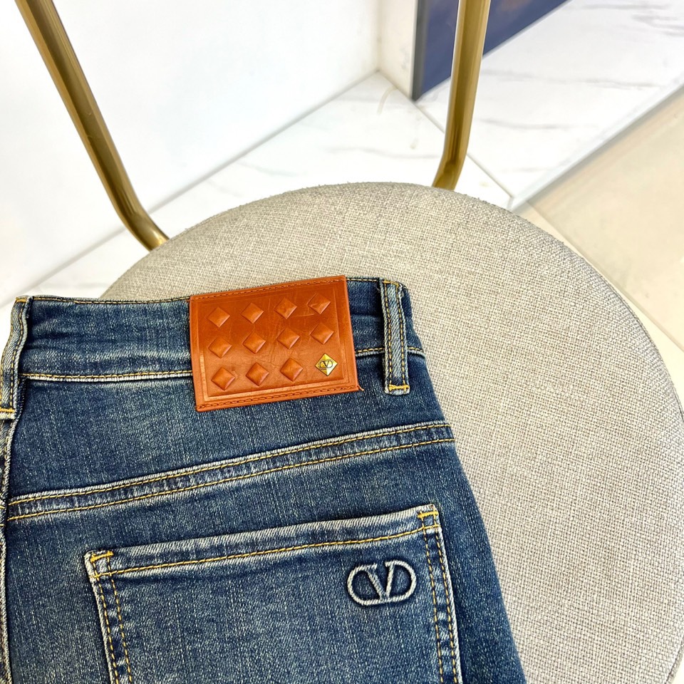 VT华伦天奴、2025秋冬新品深蓝色牛仔裤，以经典丹宁重塑现代奢华美学。后袋上方装饰标志性棕色菱格纹皮革