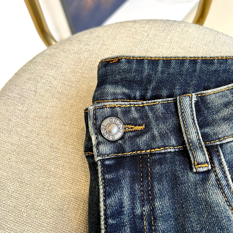 Gucc古驰、2025秋冬新品 GUCCI刺绣徽章牛仔裤，这款深蓝色牛仔裤采用品牌标志性设计，后袋处以金