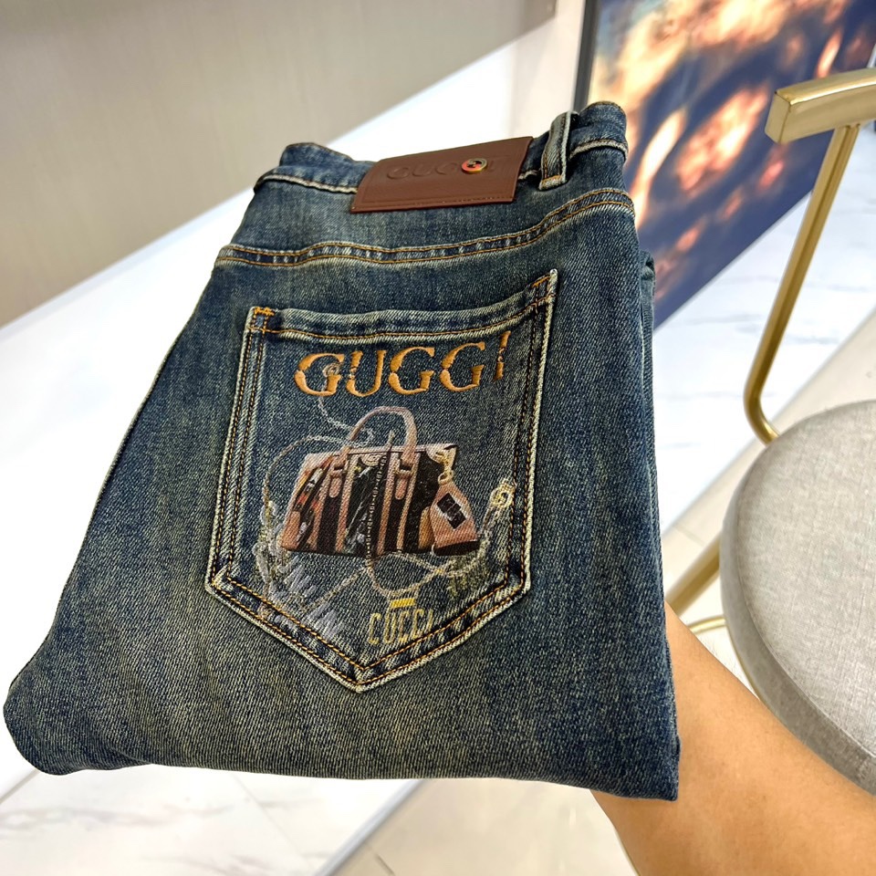 Gucc古驰、2025秋冬新品 GUCCI刺绣徽章牛仔裤，这款深蓝色牛仔裤采用品牌标志性设计，后袋处以金