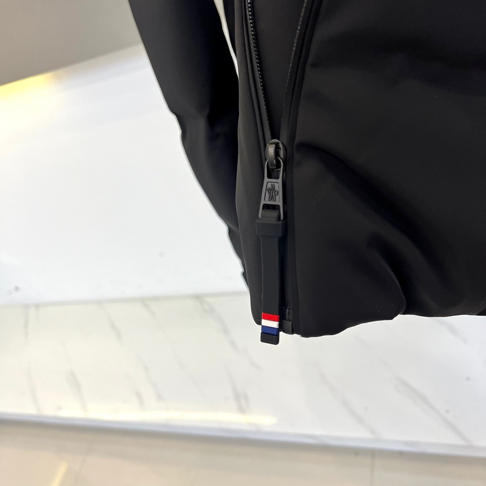 Mon蒙口、2025秋冬新品 MONCLER滑雪羽绒服。黑色长款设计通过精准的绗缝线条划分出立体块状结构