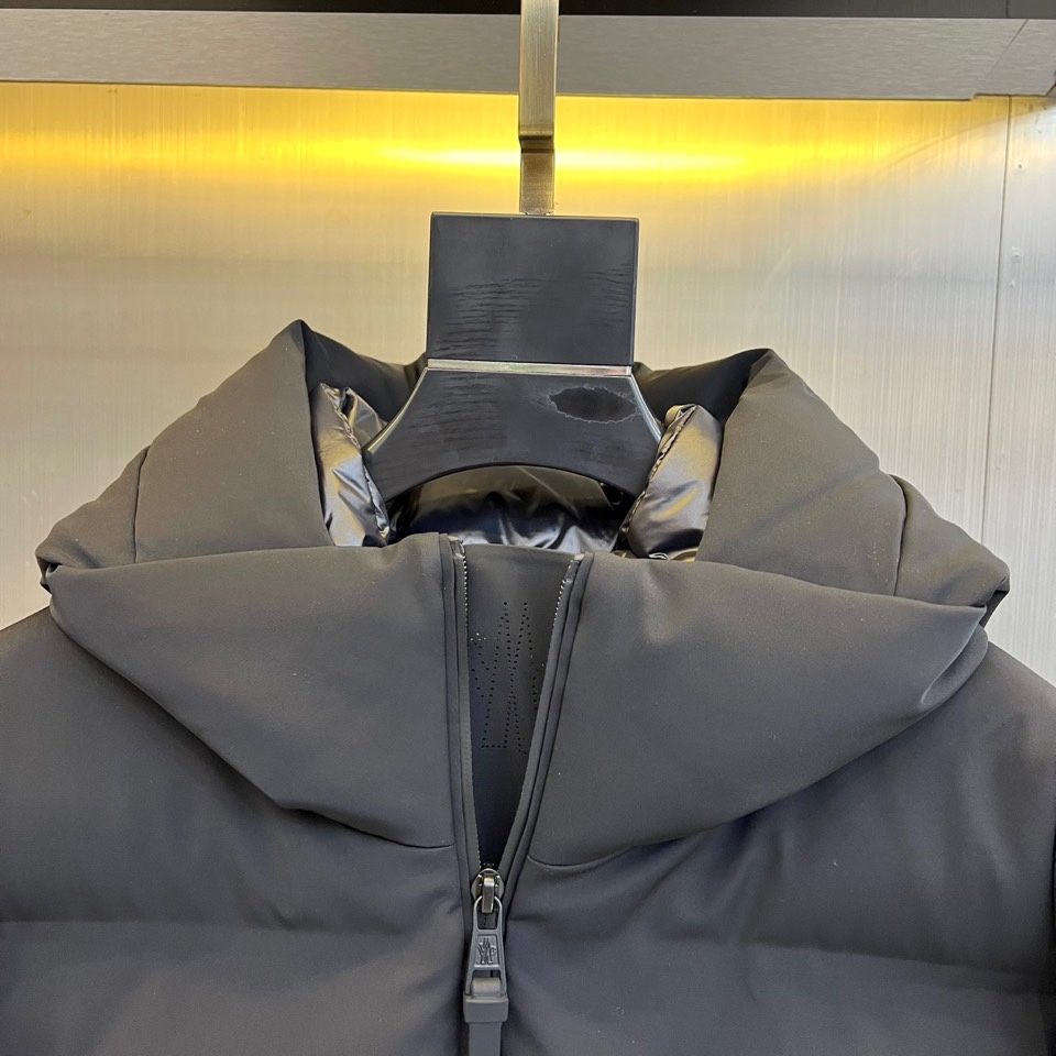 Mon蒙口、2025秋冬新品 MONCLER滑雪羽绒服。黑色长款设计通过精准的绗缝线条划分出立体块状结构