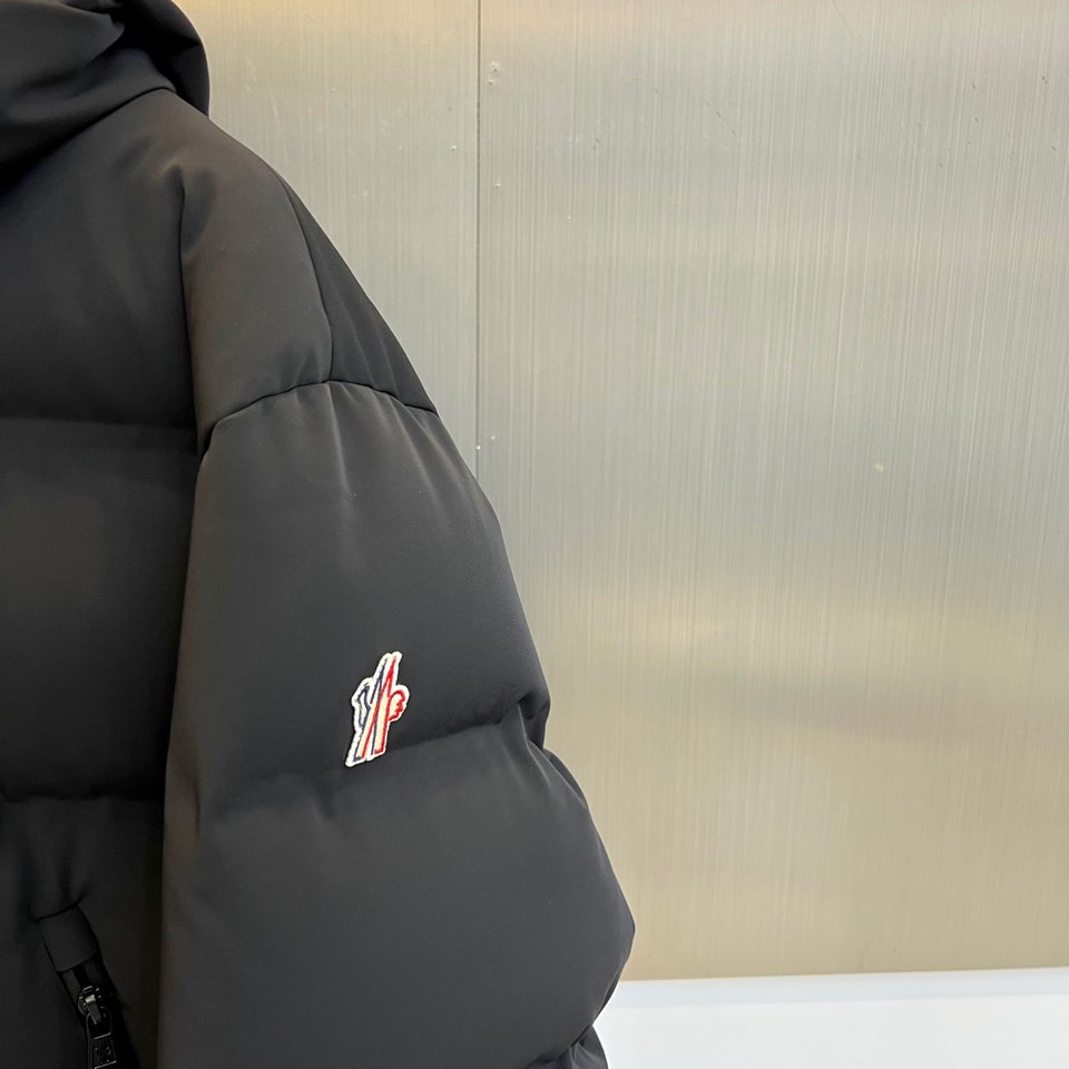 Mon蒙口、2025秋冬新品 MONCLER滑雪羽绒服。黑色长款设计通过精准的绗缝线条划分出立体块状结构
