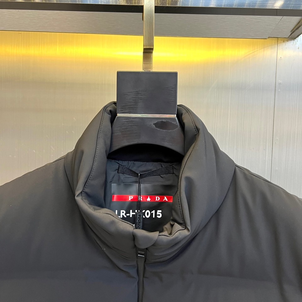 Prad普拉达、2025秋冬新品 PRADA机能风羽绒马甲。立领设计搭配无袖剪裁，正面配置黑色顺滑拉链开