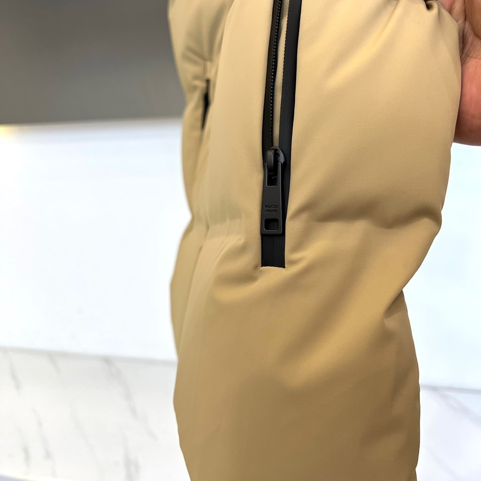 Prad普拉达、2025秋冬新品 PRADA机能风羽绒马甲。立领设计搭配无袖剪裁，正面配置黑色顺滑拉链开