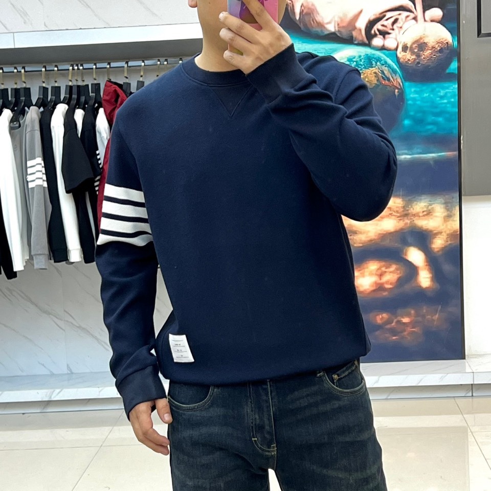 TB汤姆布朗、2025秋冬新品圆领卫衣，这款卫衣采用宽松休闲版型设计，左袖装饰四道白色条纹打造运动风尚。