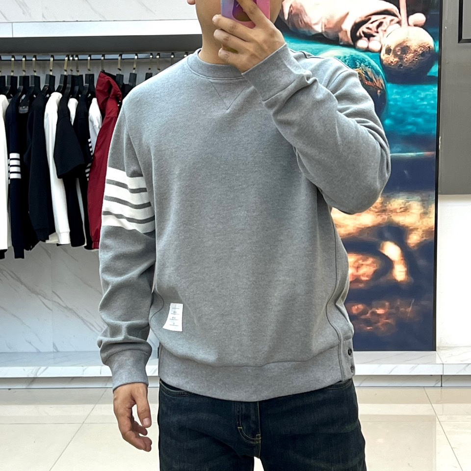 TB汤姆布朗、2025秋冬新品圆领卫衣，这款卫衣采用宽松休闲版型设计，左袖装饰四道白色条纹打造运动风尚。