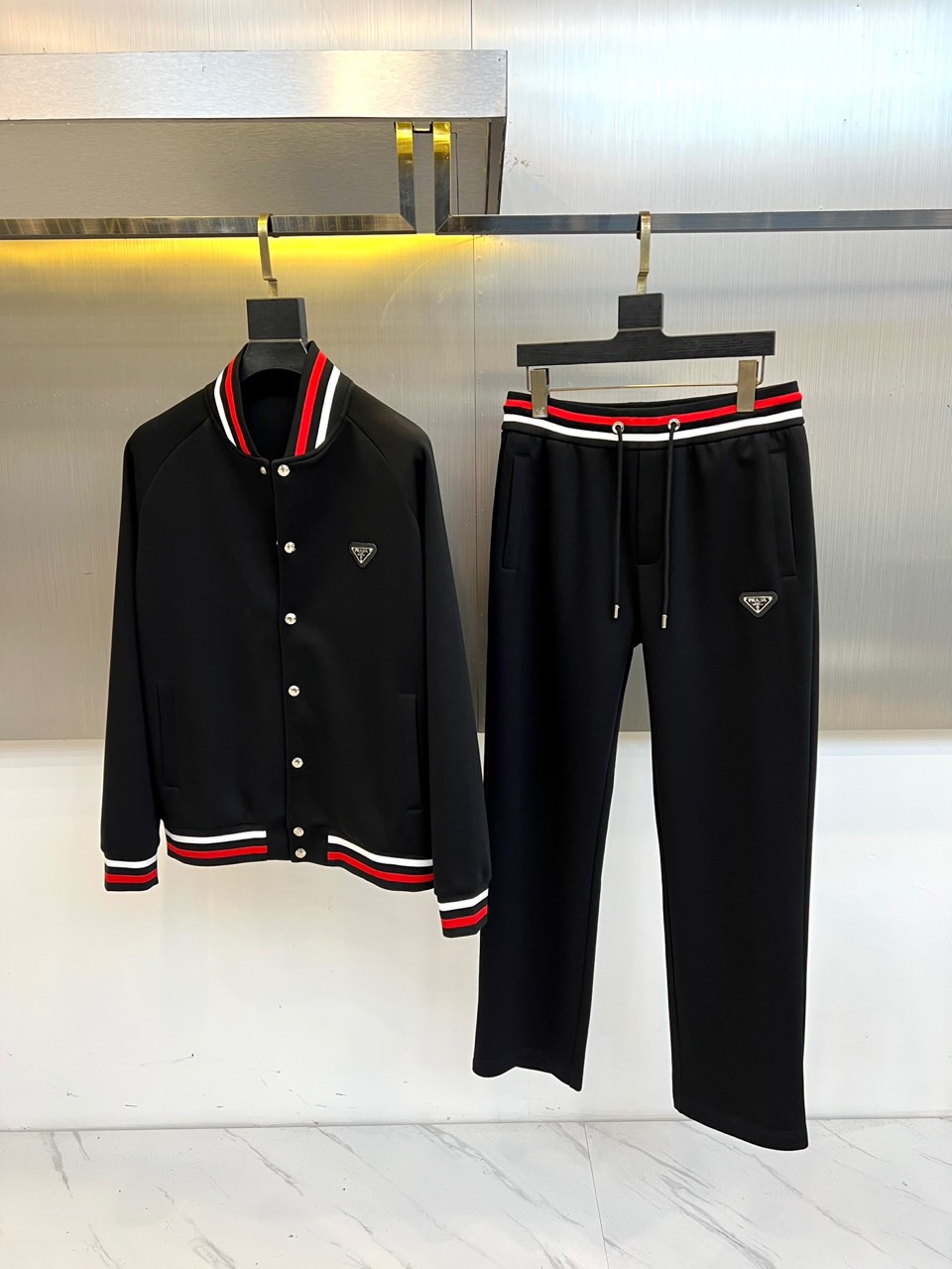Prad普拉、2025秋冬运动系列红白条纹的工业美学。2025秋冬全新运动套装，以纯粹哑光黑为画布，领口