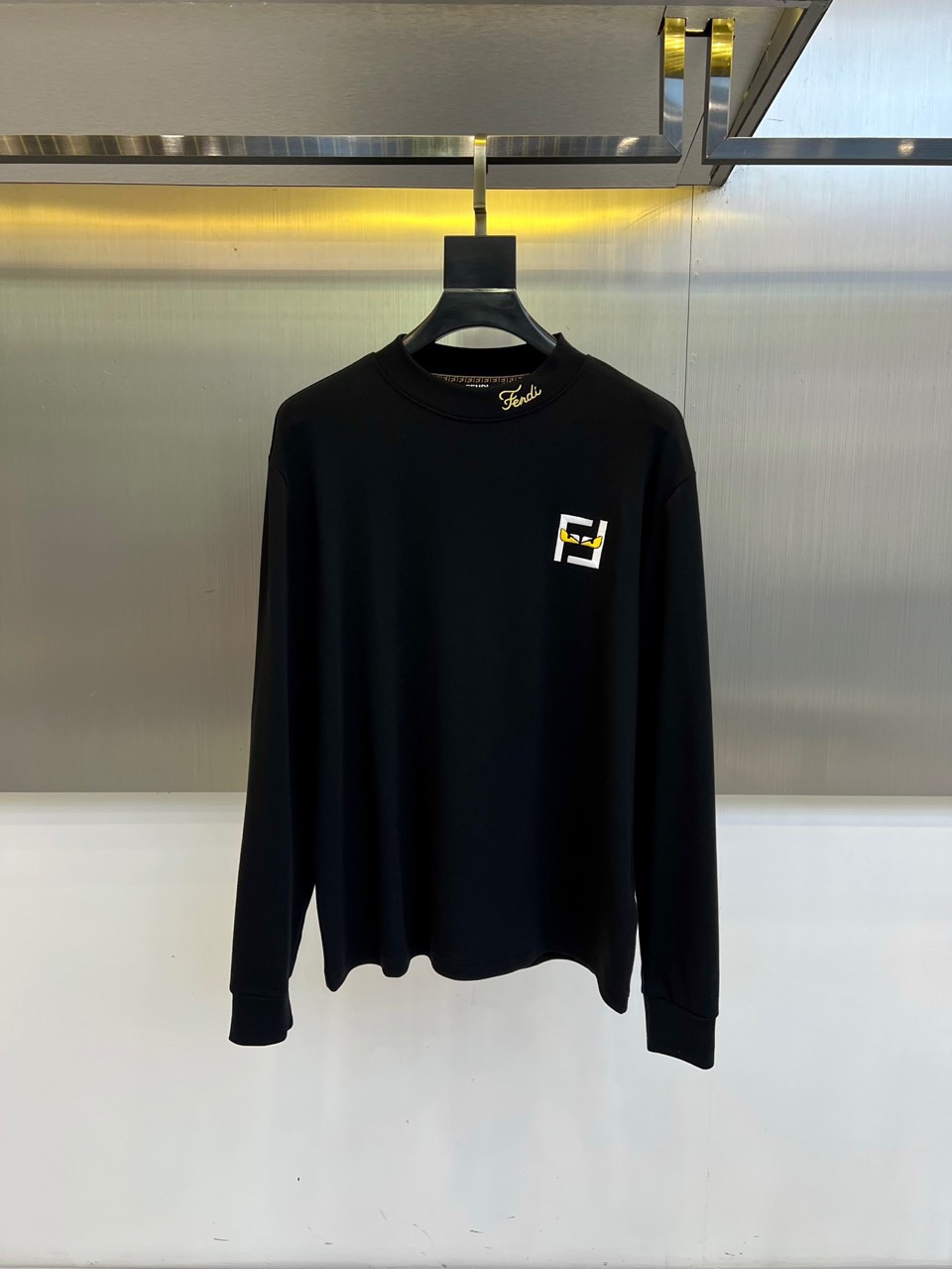 Fend芬迪、2025秋冬新品男士长袖T恤，以纯净白色诠释意式奢华美学。领口内侧饰有品牌标识，胸前点缀经