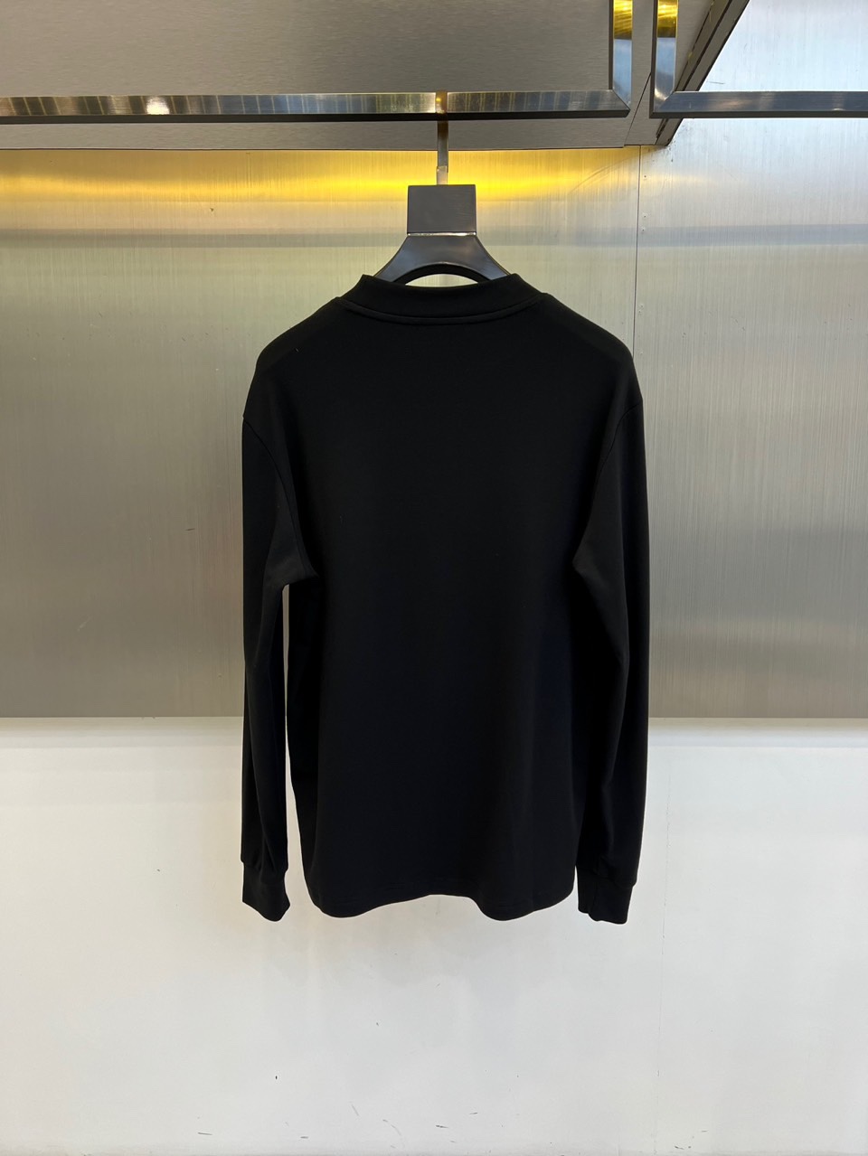 Fend芬迪、2025秋冬新品男士长袖T恤，以纯净白色诠释意式奢华美学。领口内侧饰有品牌标识，胸前点缀经