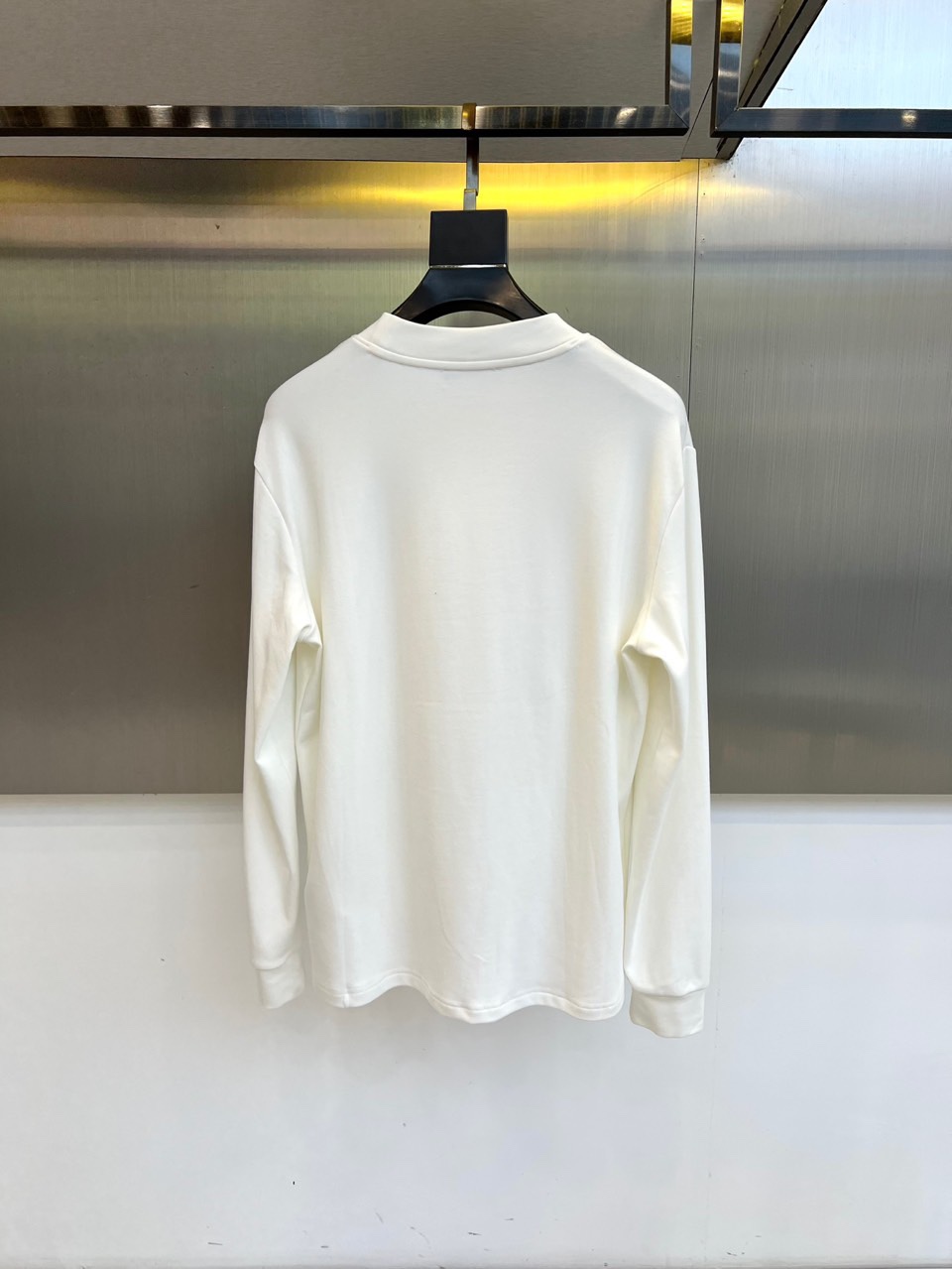 Fend芬迪、2025秋冬新品男士长袖T恤，以纯净白色诠释意式奢华美学。领口内侧饰有品牌标识，胸前点缀经