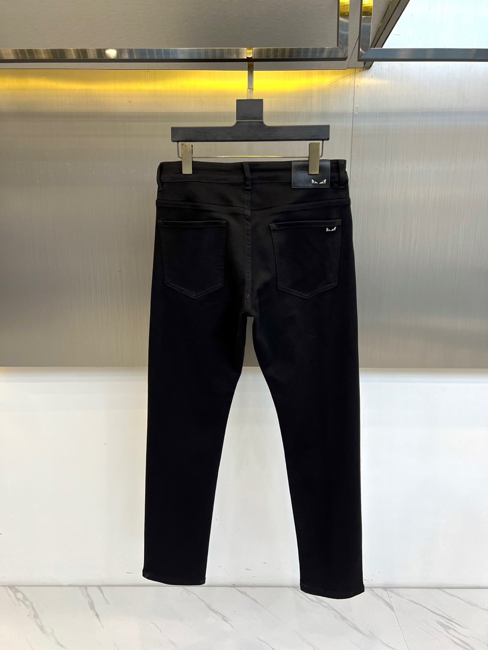 Fend芬迪、2025秋冬新品黑色牛仔裤，以极致纯黑诠释当代暗黑美学。后腰处装饰品牌标志性深色皮革标签，