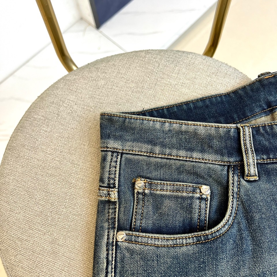 PRADA普拉、2025秋冬新品深蓝色牛仔裤，采用水洗工艺打造自然磨损与褪色效果，呈现复古质感。宽松版型