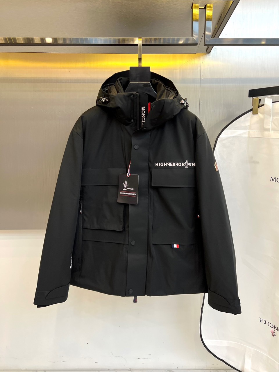 MON蒙口（高端白鹅绒）、2025秋冬新品男士高性能滑雪羽绒服，以米白色调演绎极简机能美学。连帽设计搭配