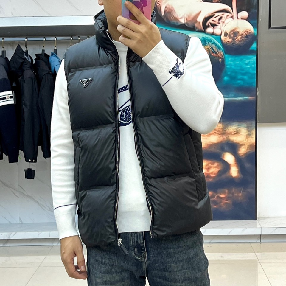 Prad普拉、2025秋冬新品 PRADA黑色绗缝羽绒马甲，这款马甲采用立领无袖设计，通过精准的菱形绗缝