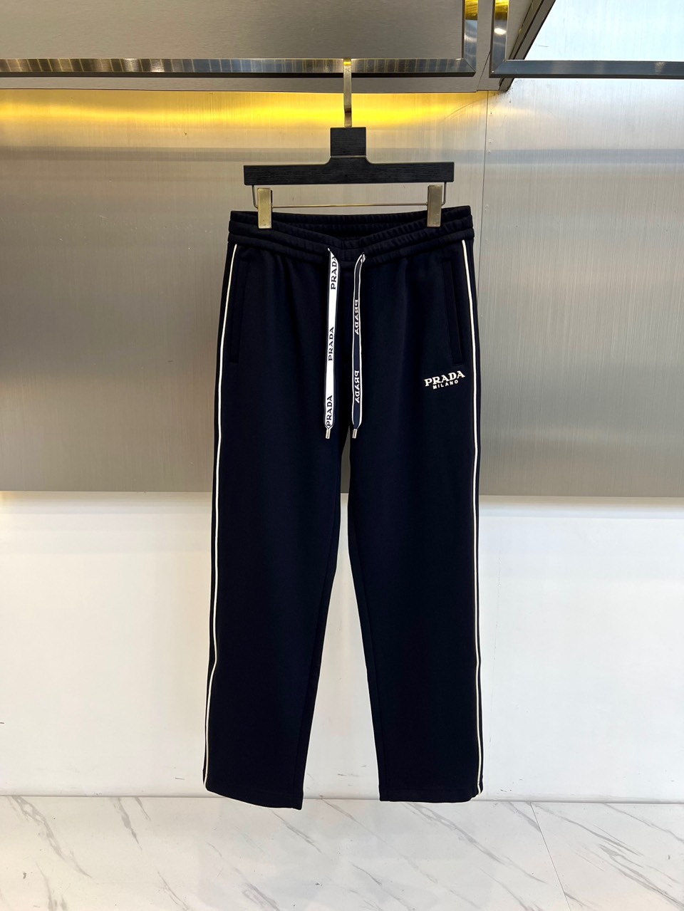 Prad普拉、2025秋冬新品 | PRADA运动加绒加厚休闲长裤，这款黑色长裤采用宽松直筒版型设计，侧